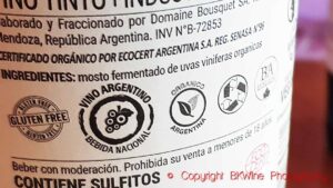 Back label on a wine bottle with certification stamps for gluten free, national drink, BDA sustainability, recycling, vegan, Ecocert and organics